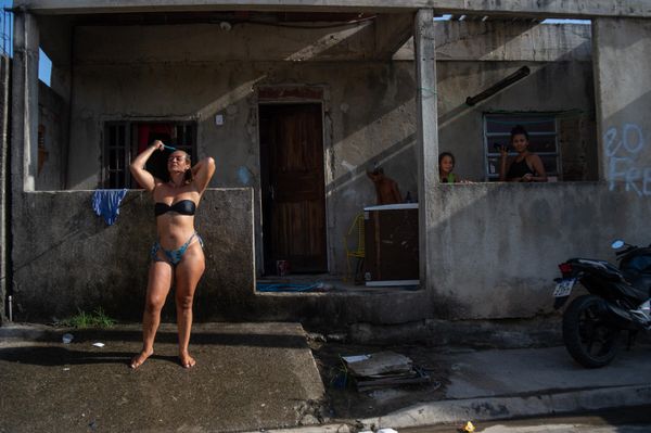 Una mujer se refresca con agua de una manguera en un caluroso día al aire libre en el barrio de Guaratiba de Río de Janeiro, Brasil. - Sputnik Mundo