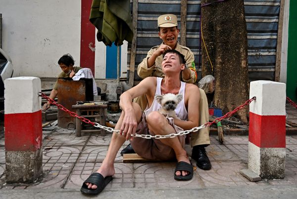 Un hombre buscando canas en la cabeza de su amigo en una calle de la ciudad de Hanoi, Vietnam. - Sputnik Mundo