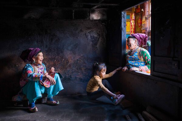 Una imagen del fotógrafo chino Sun Bin de una familia en su centenaria casa ancestral de la aldea de Zhuomulang, provincia de Yunnan, recibió una mención especial en la categoría Mejor Imagen Individual de Gente y Culturas (Best Single Image in a People and Cultures Portfolio). - Sputnik Mundo