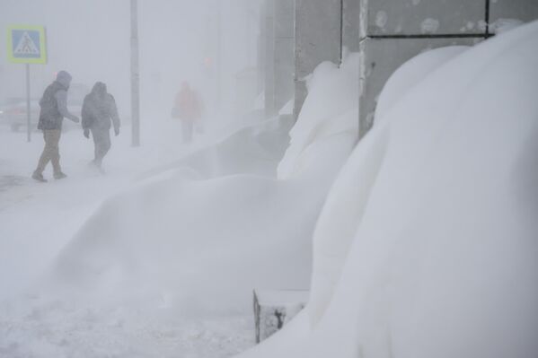 Un ciclón de nieve azota estos días la isla de Sajalín. Según los meteorólogos, hacía muchos años que no se registraban en la isla tales nevadas y vientos. La nieve ha alcanzado las plantas bajas y los coches están cubiertos hasta el techo. El transporte público no funciona, los aviones no vuelan, las guarderías están cerradas, al igual que muchas empresas, y los escolares y estudiantes se han trasladado a la educación a distancia.En la foto: la gente pasa por una calle de Yuzhno-Sajalinsk. - Sputnik Mundo