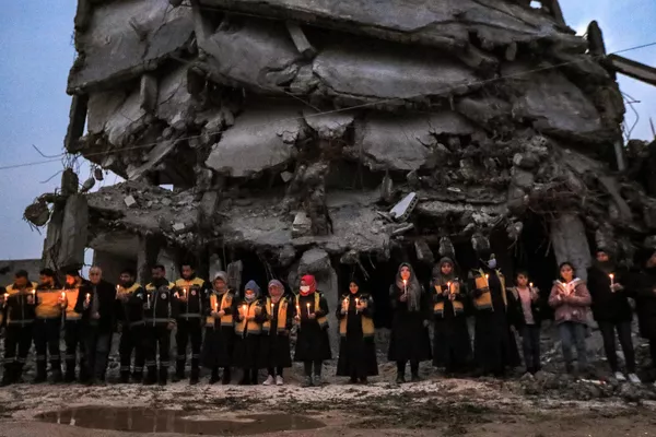 El 6 de febrero de 2023, dos potentes terremotos, con solo nueve horas de diferencia, destruyeron 160.000 edificios en Turquía y Siria. En la foto: miembros de la Defensa Civil Siria y supervivientes locales del devastador sismo del año pasado asisten a una vigilia conmemorativa en la ciudad de Jindairis, en la provincia noroccidental siria de Alepo. El 6 de febrero de 2023, dos potentes terremotos, con solo nueve horas de diferencia, destruyeron 160.000 edificios en Turquía y Siria. En la foto: miembros de la Defensa Civil Siria y supervivientes locales del devastador sismo del año pasado asisten a una vigilia conmemorativa en la ciudad de Jindairis, en la provincia noroccidental siria de Alepo. - Sputnik Mundo