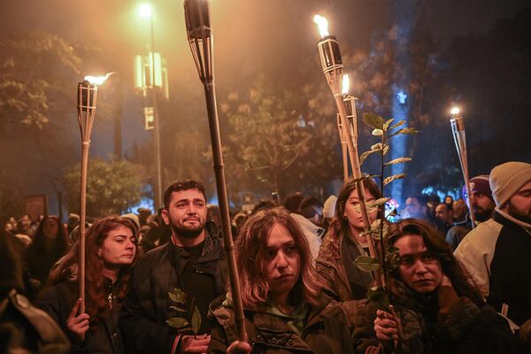 En Turquía, quienes perdieron sus hogares a causa del movimiento telúrico, fueron alojados temporalmente en ciudades contenedoras, bloques metálicos grises de 3x7 m. La población de estos centros asciende a 560.000 personas.En la foto: participantes en una vigilia conmemorativa en el aniversario del devastador terremoto de Antioquía. - Sputnik Mundo