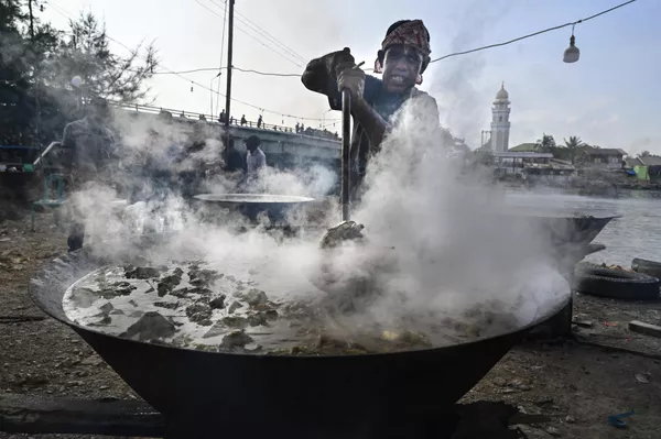 Un hombre prepara un plato tradicional de curry para los residentes locales en el Día de pesca en Banda Aceh, Indonesia. - Sputnik Mundo