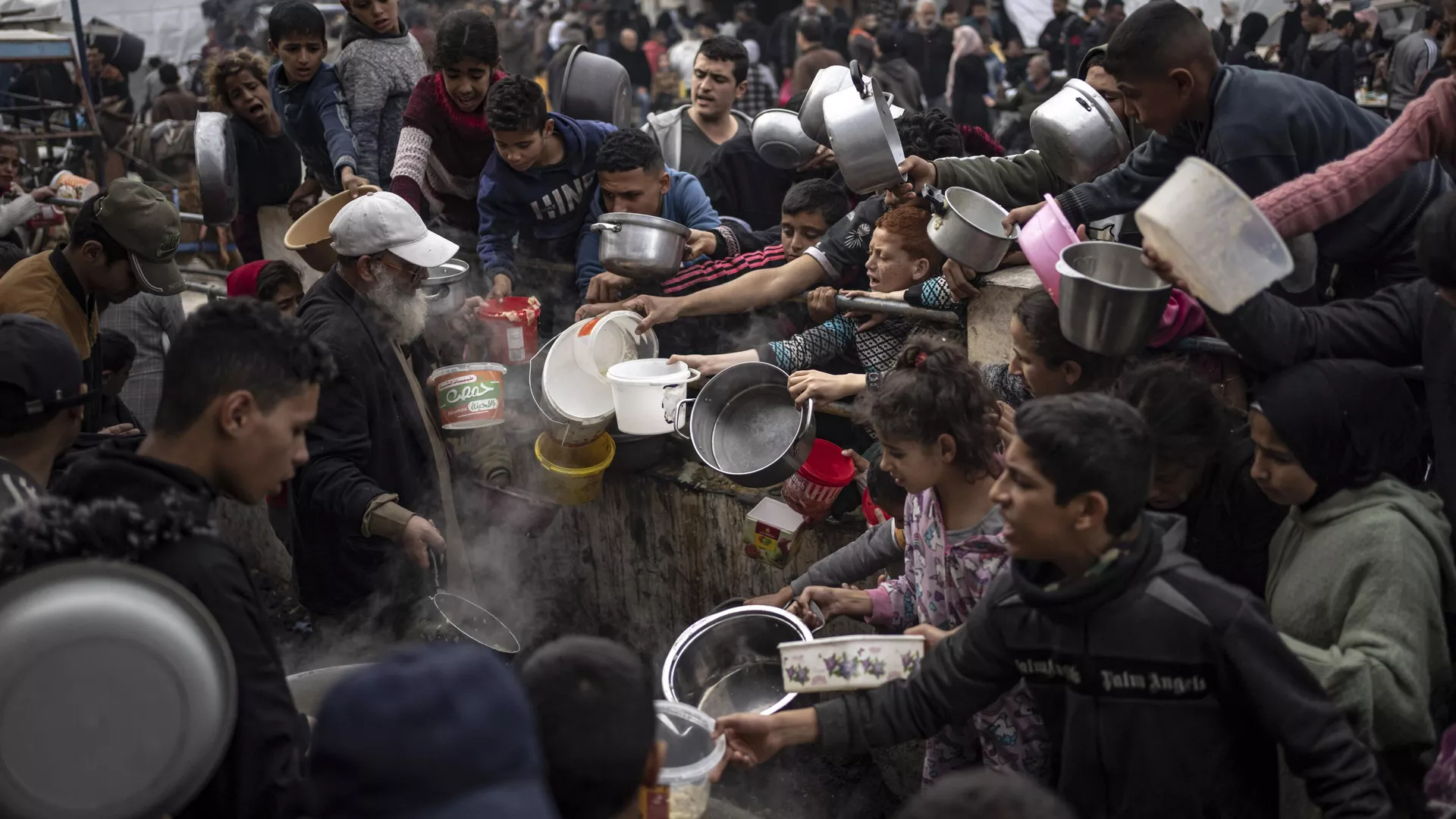 Palestinos esperan recibir alimentos en la ciudad de Rafah
