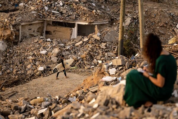 Un surfista pasa junto a los escombros de las casas de la ciudad de Imsouane, demolidas en el marco de un plan de destrucción de construcciones ilegales en la costa marroquí. Un surfista pasa junto a los escombros de las casas de la ciudad de Imsouane, demolidas en el marco de un plan de destrucción de construcciones ilegales en la costa marroquí. - Sputnik Mundo