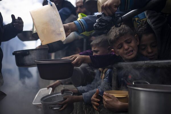 Palestinos hacen cola para recibir comida gratuita en la ciudad de Rafah, en el sur de la Franja de Gaza. Palestinos hacen cola para recibir comida gratuita en la ciudad de Rafah, en el sur de la Franja de Gaza. - Sputnik Mundo