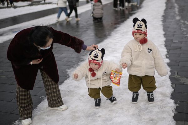 Niños pasean por la ciudad un día después de una nevada en Pekín, China. Niños pasean por la ciudad un día después de una nevada en Pekín, China. - Sputnik Mundo