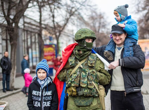 Para el 2 de marzo, todos los puestos de control fronterizo en el territorio de Crimea pasaron a estar bajo el control de las autoridades de esa república. El bloqueo de las unidades de las FFAA de Ucrania continuó en toda la península. A los militares se les ofreció jurar lealtad al pueblo de Crimea o devolver sus armas a los almacenes. Los efectivos de la unidad de Fuerzas Especiales Bérkut recibieron en masa pasaportes rusos. En la foto: residentes de Simferópol se fotografían con militares rusos. - Sputnik Mundo