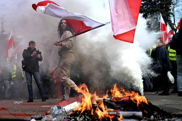 Manifestantes encienden botellas frente al Sejm de la República de Polonia, Cámara Baja del Parlamento, mientras asisten a una protesta de agricultores contra las medidas climáticas de la UE y las importaciones ucranianas en Varsovia, Polonia. - Sputnik Mundo