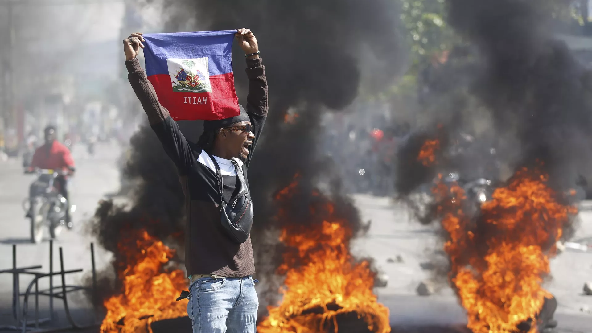 Un manifestante sostiene una bandera haitiana durante las protestas que exigen la dimisión del primer ministro Ariel Henry en Puerto Príncipe, Haití, el 1 de marzo de 2024