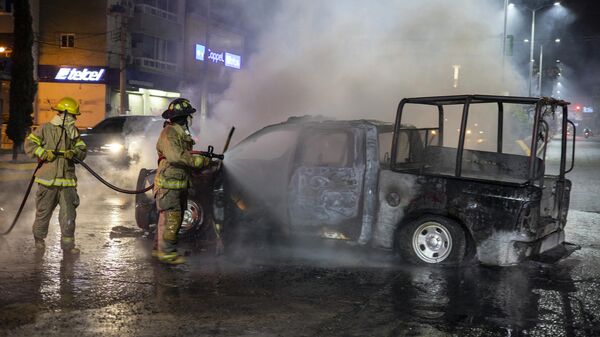 Bomberos apagan una camioneta robada e incendiada por presuntos estudiantes de la Escuela Normal Rural de Ayotzinapa en Chilpancingo, Estado de Guerrero, México, el 7 de marzo, 2024 - Sputnik Mundo