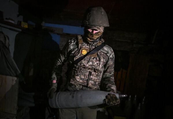 En la foto: un artillero del grupo Sur lleva en las manos un proyectil de 152 mm. - Sputnik Mundo