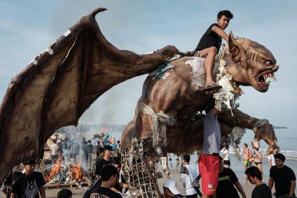Un hombre intenta cortar la cabeza de Ogoh-ogoh, una estatua que simboliza un espíritu maligno en vísperas del Año Nuevo conforme al calendario hindú balinés, en Indonesia. - Sputnik Mundo
