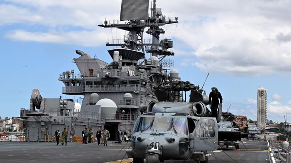 Un MH-60 Seahawk al lado del buque de asalto anfibio USS Tripoli (LHA-7) de la Marina de los EEUU, mientras está atracado en la base de la flota en Sídney el 4 de noviembre de 2022.  - Sputnik Mundo