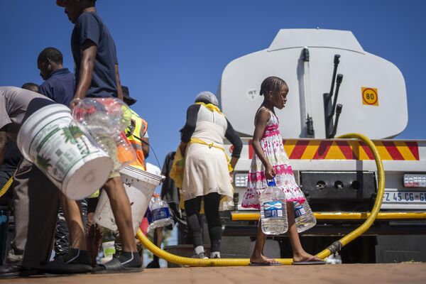 El 70% de la superficie terrestre está cubierta de agua, pero casi toda es salada. La proporción de masas de agua dulce ronda el 2,5%.En la foto: residentes del municipio sudafricano de Soweto haciendo fila para recoger agua. - Sputnik Mundo