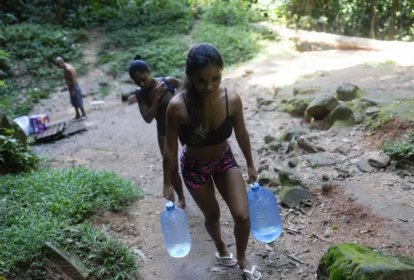 Una joven llevando botellas de agua potable en Río de Janeiro, Brasil. Una joven llevando botellas de agua potable en Río de Janeiro, Brasil. - Sputnik Mundo