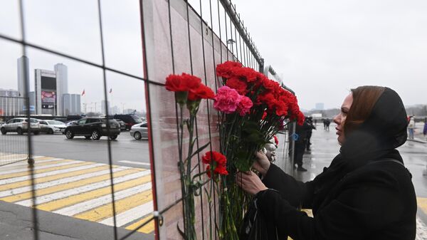 La gente lleva flores a la sala de conciertos Crocus City Hall en la región de Moscú, Rusia - Sputnik Mundo