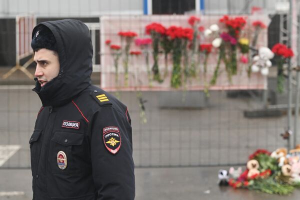 En toda Rusia se están organizando concentraciones en recuerdo de los fallecidos en el atentado terrorista. También se están llevando flores a la embajada rusa en distintos países.En la foto: un agente de policía delante de la sala de conciertos donde se produjeron los trágicos acontecimientos. - Sputnik Mundo