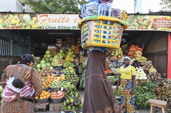Iftar es la segunda comida del día. Se celebra después de la oración de la tarde, según la hora local. Comienza inmediatamente después de la puesta de sol.En la foto: una mujer lleva alimentos durante el mes sagrado del Ramadán en Abiyán, Costa de Marfil. - Sputnik Mundo