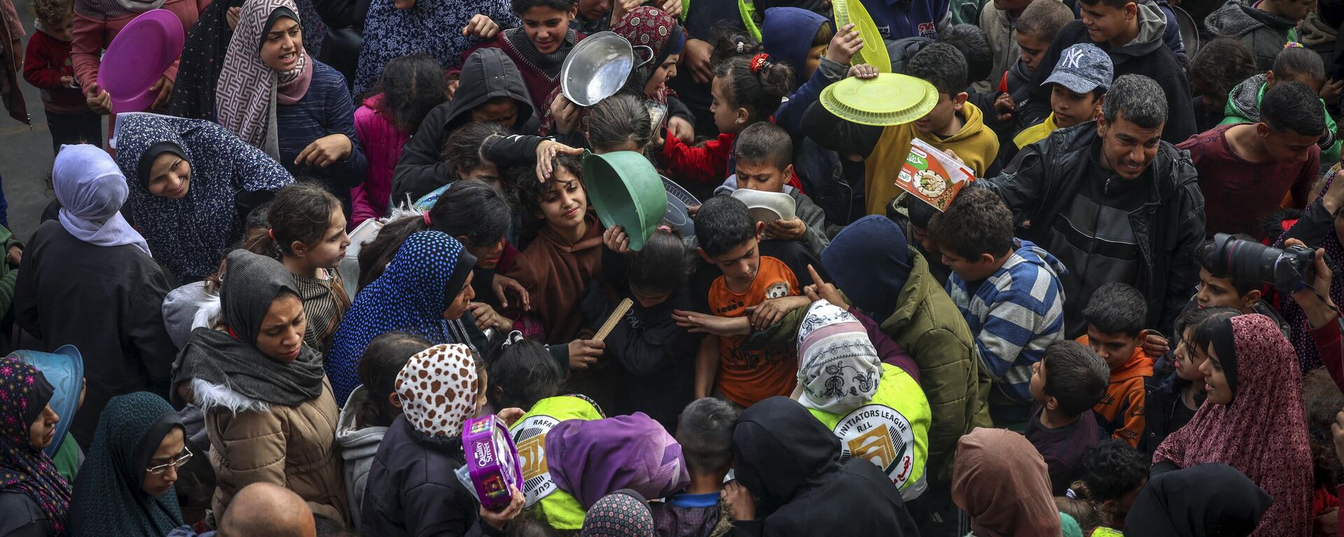 Palestinos desplazados se reúnen para recibir comida en una escuela gubernamental en Rafah, en el sur de la Franja de Gaza - Sputnik Mundo, 1920, 28.03.2024