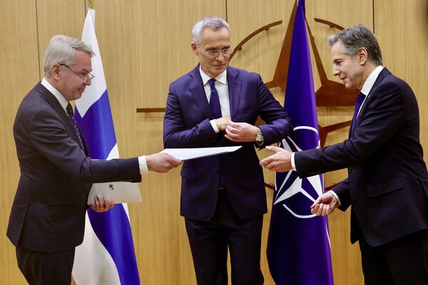 El ministro finlandés de Asuntos Exteriores, Pekka Haavisto, entrega los documentos de adhesión de Finlandia a la OTAN al secretario general de la OTAN, Jens Stoltenberg, y al secretario de Estado estadounidense, Antony Blinken, durante una ceremonia de adhesión en una reunión de ministros de Asuntos Exteriores de la OTAN, en la sede de la organización en Bruselas, el 4 de abril de 2023 - Sputnik Mundo