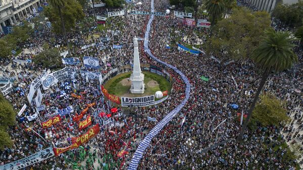 Manifestantes portando pancartas con fotos de personas desaparecidas durante la dictadura militar de 1976-1983, en una marcha para conmemorar el 48 aniversario del golpe en la Plaza de Mayo de Buenos Aires, Argentina. - Sputnik Mundo