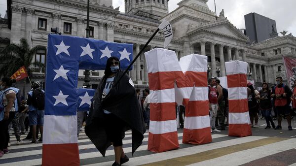 Un manifestante camina durante una protesta frente al Congreso argentino mientras los legisladores se preparan para votar una ley para ratificar el acuerdo del gobierno con el FMI para refinanciar unos 45.000 millones de dólares en deuda, en Buenos Aires - Sputnik Mundo