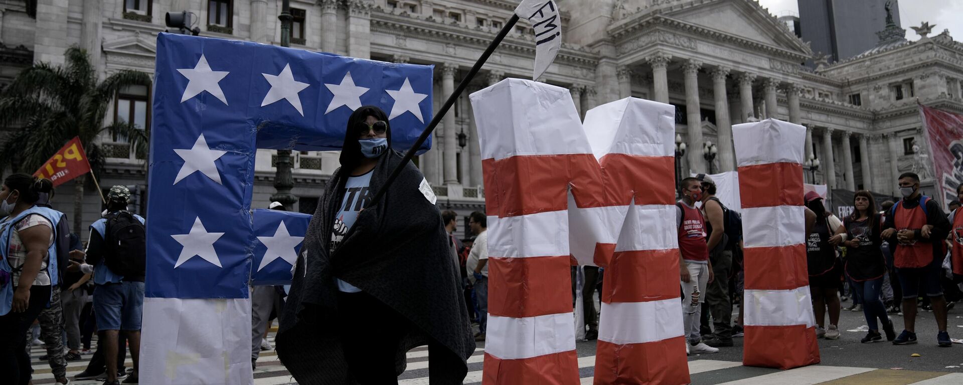 Un manifestante camina durante una protesta frente al Congreso argentino mientras los legisladores se preparan para votar una ley para ratificar el acuerdo del gobierno con el FMI para refinanciar unos 45 mil millones de dólares en deuda, en Buenos Aires - Sputnik Mundo, 1920, 27.06.2024