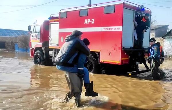 Agentes del Ministerio de Emergencias ruso y de los servicios municipales evacúan a ciudadanos discapacitados desde la zona de emergencias de la región de Oremburgo. - Sputnik Mundo