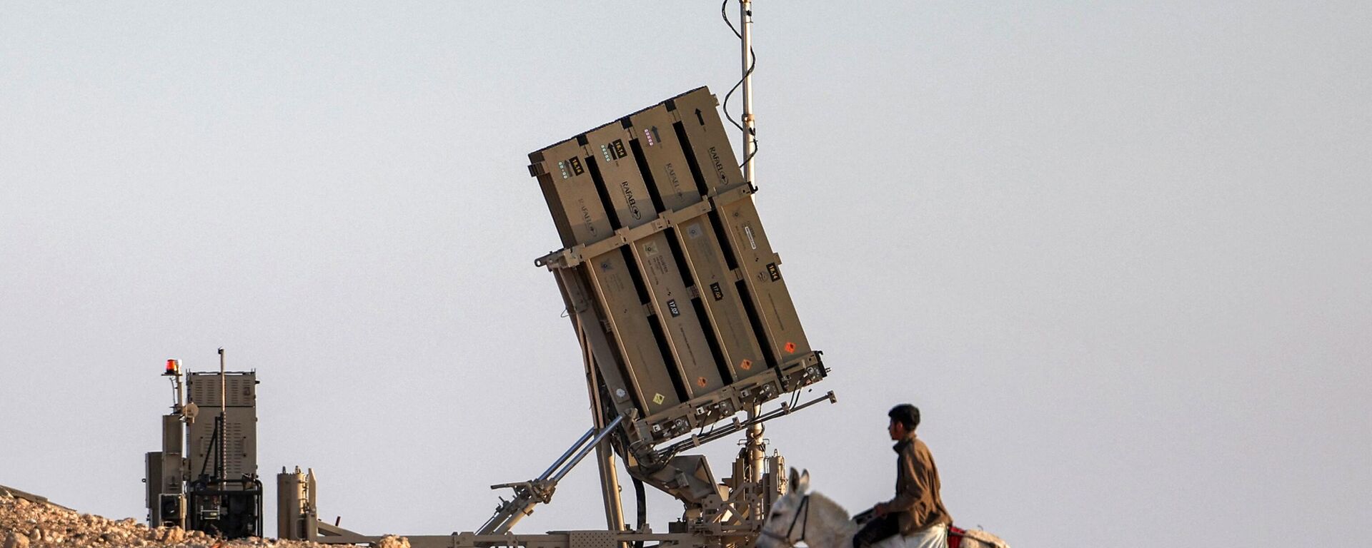 Un niño monta en burro cerca de una de las baterías del sistema israelí de defensa antimisiles Cúpula de Hierro, en una aldea no reconocida por las autoridades israelíes en el sur del desierto del Néguev, el 14 de abril de 2024.
 - Sputnik Mundo, 1920, 14.04.2024