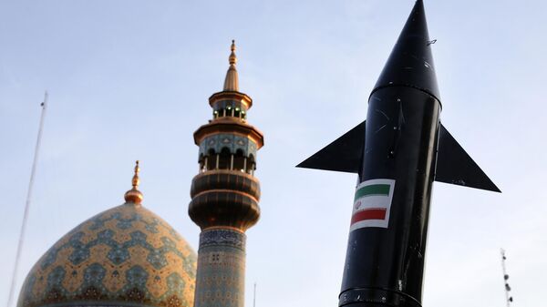 Manifestantes iraníes portan un modelo de misil mientras se ve al fondo el minarete y la cúpula de una mezquita durante una reunión antiisraelí en la plaza Felestin (Palestina) en Teherán - Sputnik Mundo