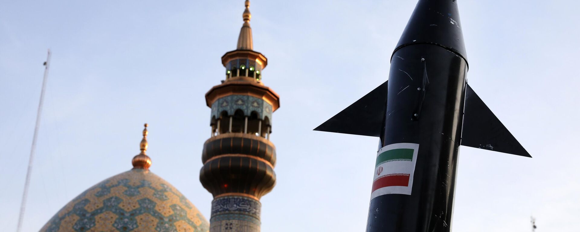 Manifestantes iraníes portan un modelo de misil mientras se ve al fondo el minarete y la cúpula de una mezquita durante una reunión antiisraelí en la plaza Felestin (Palestina) en Teherán - Sputnik Mundo, 1920, 09.08.2024