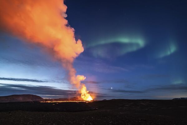 Vista de la lava que se eleva del volcán con la aurora boreal como telón de fondo, el 25 de marzo de 2024. - Sputnik Mundo