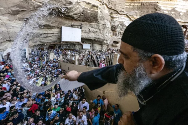 Un sacerdote copto ortodoxo rocía con agua bendita a los fieles durante el servicio del Domingo de Ramos en el Monasterio de San Simón el Curtidor, en El Cairo. Un sacerdote copto ortodoxo rocía con agua bendita a los fieles durante el servicio del Domingo de Ramos en el Monasterio de San Simón el Curtidor, en El Cairo. - Sputnik Mundo