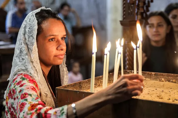 Una niña enciende una vela durante la misa del Domingo de Ramos en la iglesia de San Porfirio en Gaza. Una niña enciende una vela durante la misa del Domingo de Ramos en la iglesia de San Porfirio en Gaza. - Sputnik Mundo