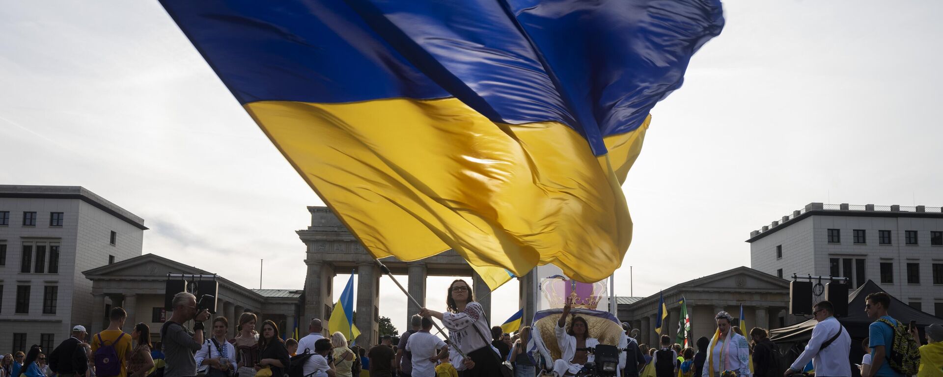 Una mujer ondea una enorme bandera ucraniana durante la manifestación para conmemorar el 32.° aniversario de la independencia de Ucrania en Berlín, Alemania, el 24 de agosto de 2023 - Sputnik Mundo, 1920, 27.09.2024