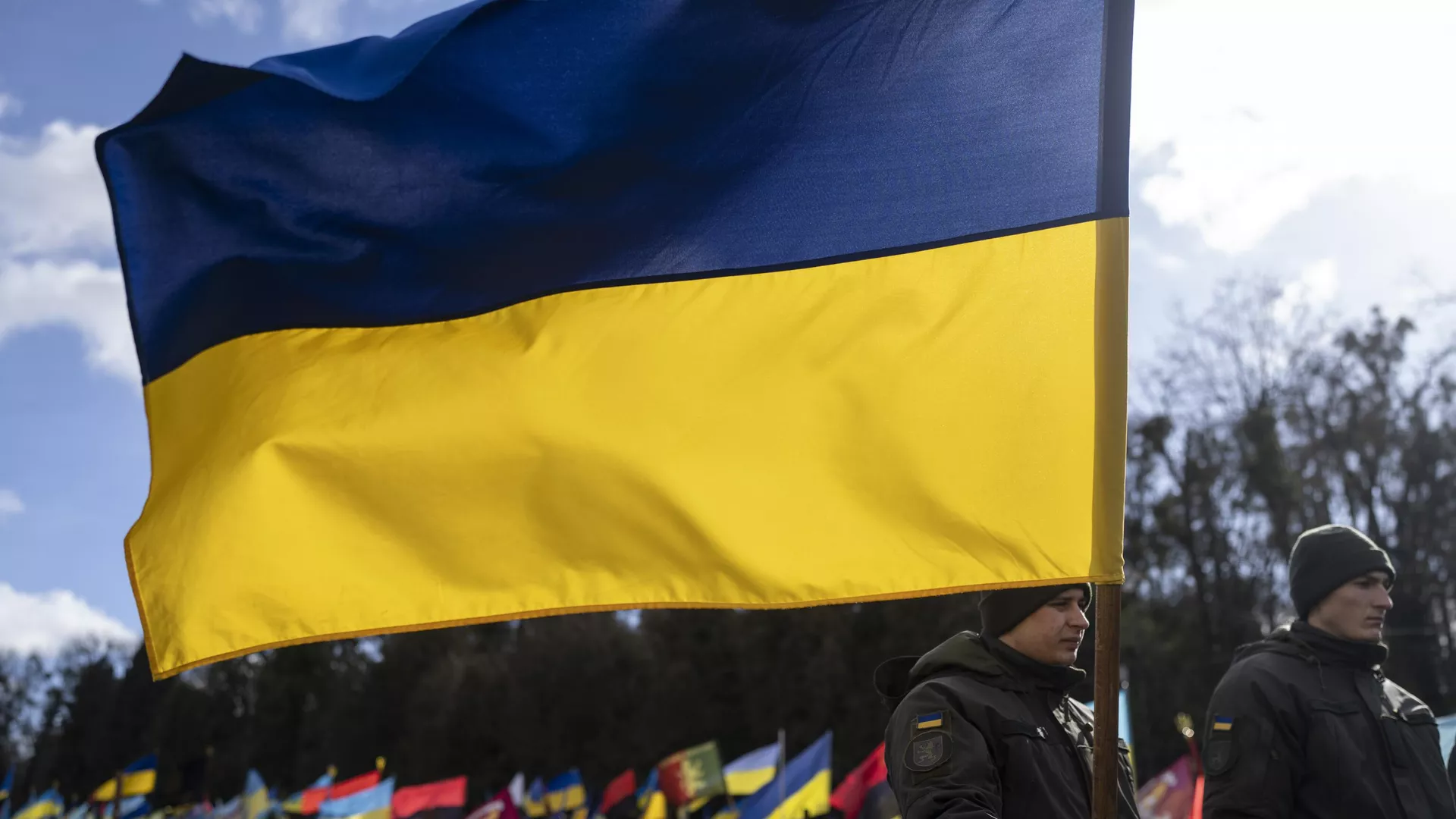 Un soldado ucraniano sostiene una bandera ucraniana en un cementerio de Ucrania Un soldado ucraniano sostiene una bandera ucraniana en un cementerio de Ucrania