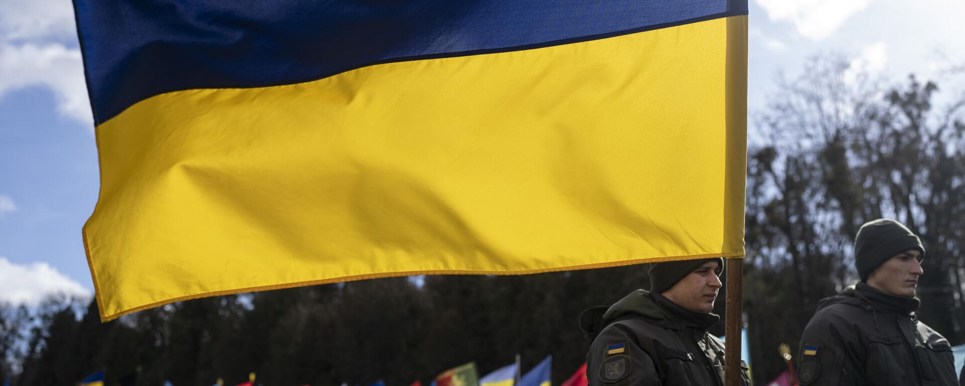 Un soldado ucraniano sostiene una bandera ucraniana en un cementerio de Ucrania - Sputnik Mundo, 1920, 30.04.2024