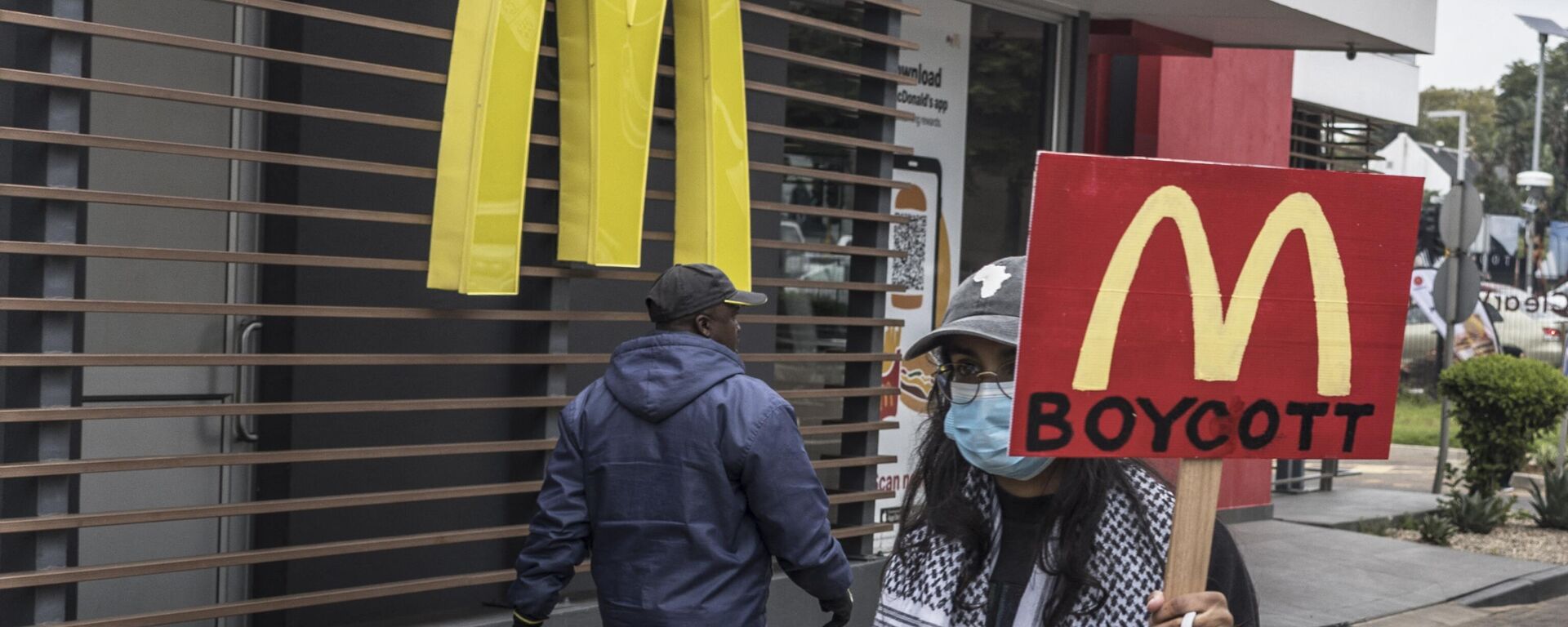 Un manifestante con una pancarta que pide boicotear la cadena de comida rápida McDonald's por su apoyo a Israel  - Sputnik Mundo, 1920, 30.04.2024