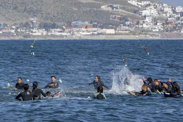Surfistas lanzan flores durante un homenaje a sus 3 colegas desaparecidos en Ensenada, México. Surfistas lanzan flores durante un homenaje a sus 3 colegas desaparecidos en Ensenada, México. - Sputnik Mundo