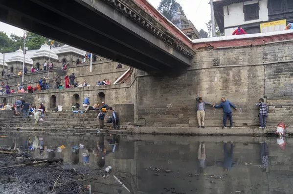 Devotos hindúes regresan a través de un estrecho saliente tras ofrecer oraciones ante el ídolo Astamatrika (un grupo de ocho diosas hinduistas representadas juntas) a orillas del río Bagmati en Katmandú, Nepal. Devotos hindúes regresan a través de un estrecho saliente tras ofrecer oraciones ante el ídolo Astamatrika (un grupo de ocho diosas hinduistas representadas juntas) a orillas del río Bagmati en Katmandú, Nepal. - Sputnik Mundo