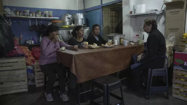 Los voluntarios comen antes de distribuir alimentos y servir comidas calientes en un comedor de beneficencia en Buenos Aires (archivo) - Sputnik Mundo
