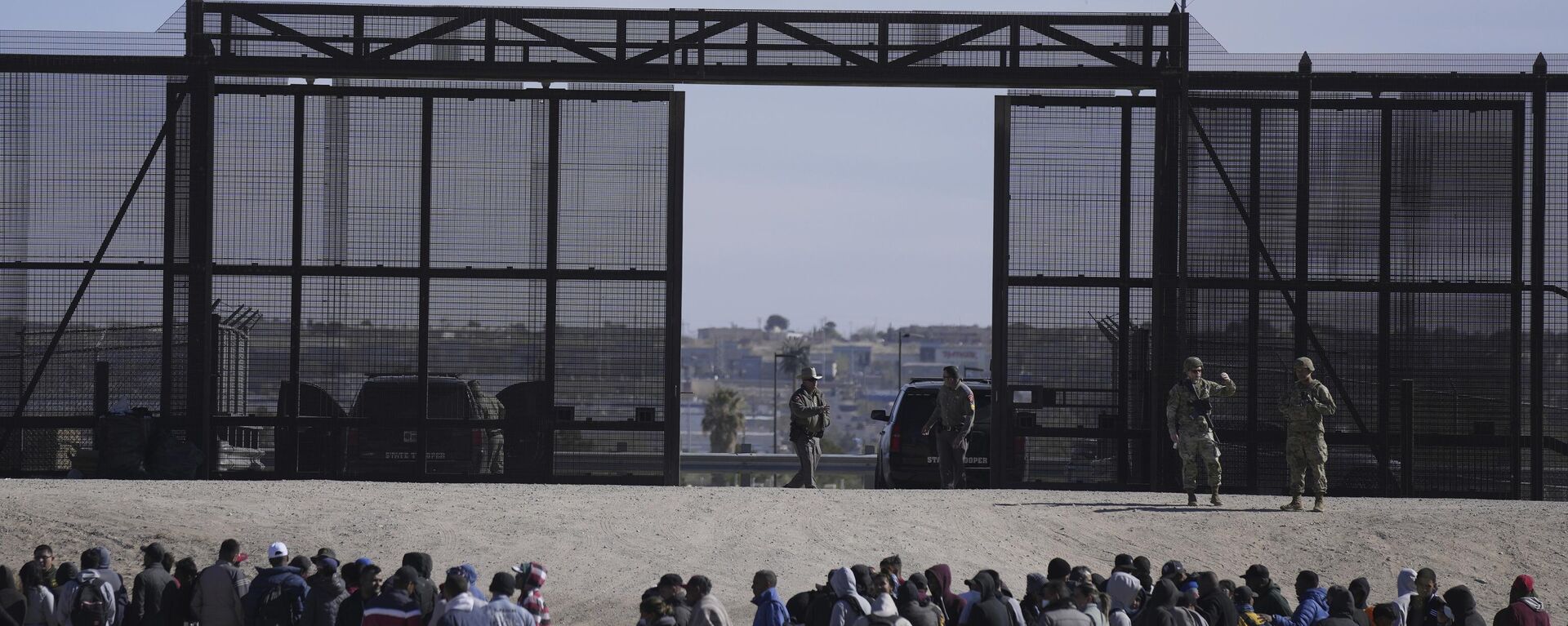 Migrantes que cruzaron la frontera de México hacia Estados Unidos esperan junto al muro fronterizo, donde hacen guardia agentes de la Patrulla Fronteriza (archivo)  - Sputnik Mundo, 1920, 05.09.2024