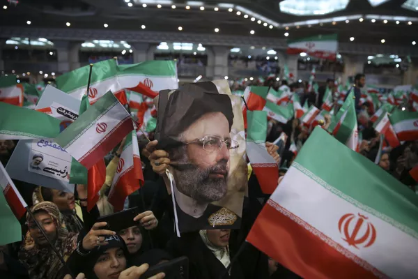Partidarios de Raisi sostienen su foto y ondean la bandera iraní durante un mitin por las elecciones presidenciales de 2017 en Teherán, Irán, el 16 de mayo de 2017. Partidarios de Raisi sostienen su foto y ondean la bandera iraní durante un mitin por las elecciones presidenciales de 2017 en Teherán, Irán, el 16 de mayo de 2017. - Sputnik Mundo