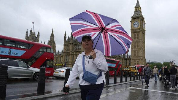 Una mujer camina frente al Parlamento, en Londres, el 22 de mayo de 2024 - Sputnik Mundo