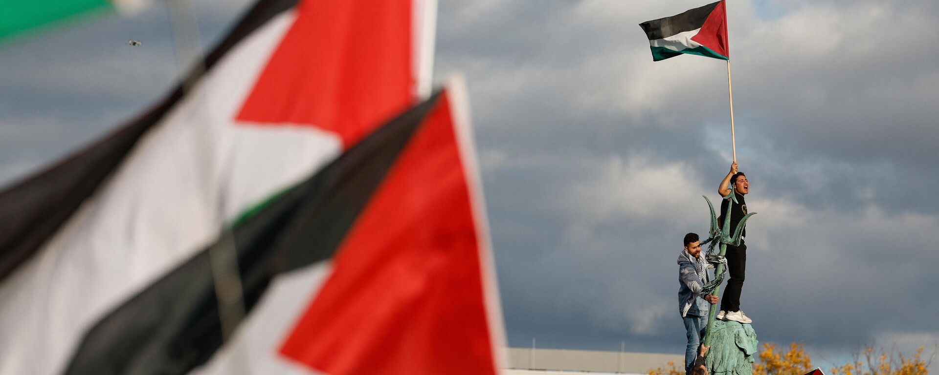 Un manifestante ondea la bandera palestina mientras se encuentra en la Fuente de Neptuno durante una protesta en apoyo a los palestinos bajo el lema 'Palestina libre' en Berlín, Alemania, el 4 de noviembre de 2023 - Sputnik Mundo, 1920, 31.05.2024