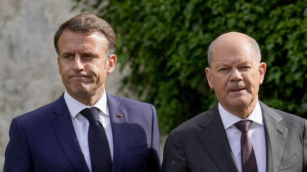 El presidente francés, Emmanuel Macron, y el canciller alemán, Olaf Scholz, caminan por el jardín de la casa de huéspedes del Gobierno alemán, Palacio de Meseberg, al Consejo Ministerial franco-alemán en Meseberg, Alemania, el 28 de mayo de 2024.  - Sputnik Mundo
