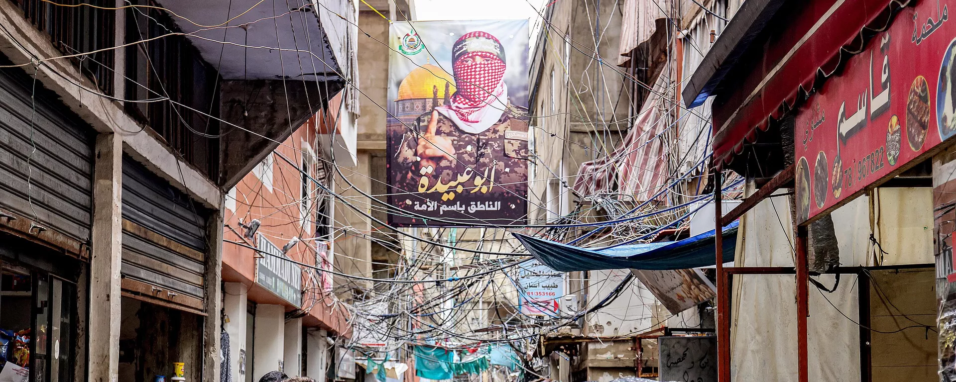 Una pancarta de Abu Obeida, el portavoz de las Brigadas Qassam de Hamás, con un lema en árabe que dice portavoz de la nación, cuelga sobre un callejón al sur de Beirut, el 5 de febrero de 2024.  - Sputnik Mundo, 1920, 06.06.2024