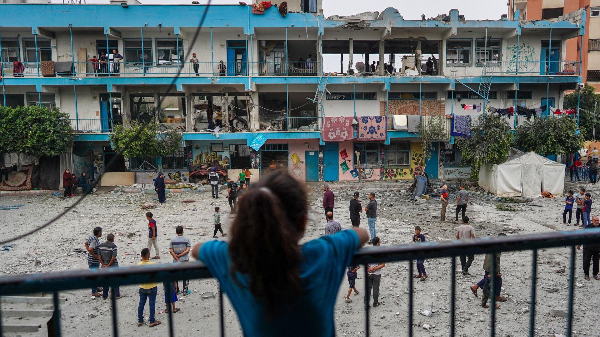 El 6 de junio de 2024, una niña palestina observa una escuela de la ONU que alberga a personas desplazadas y que fue alcanzada durante un bombardeo israelí en Nuseirat, en el centro de la Franja de Gaza. - Sputnik Mundo, 1920, 23.06.2024