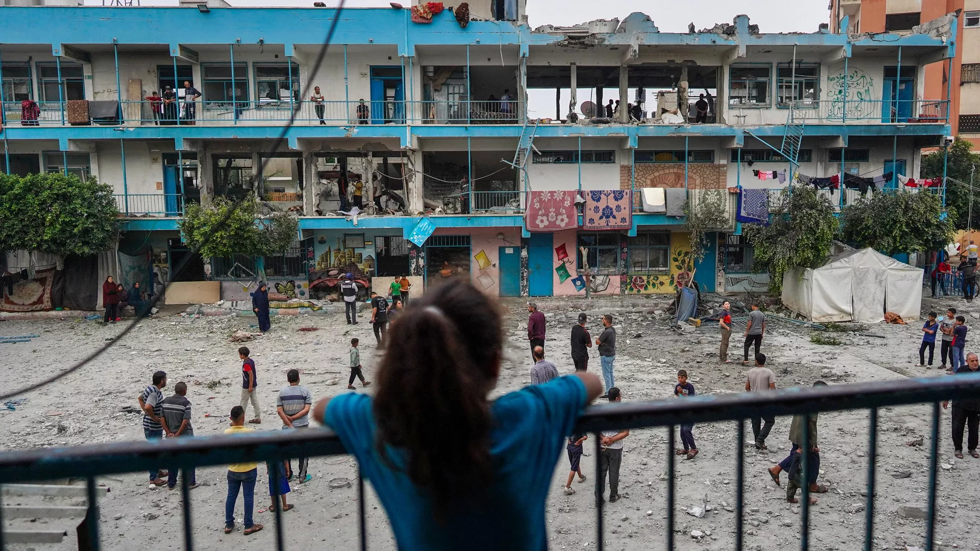 El 6 de junio de 2024, una niña palestina observa una escuela de la ONU que alberga a personas desplazadas y que fue alcanzada durante un bombardeo israelí en Nuseirat, en el centro de la Franja de Gaza.